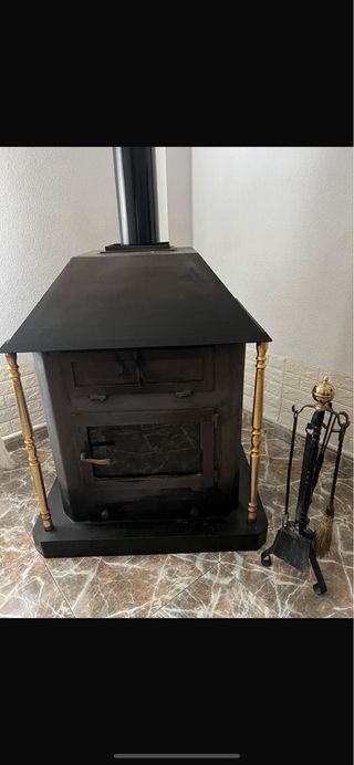 Estufa de leña negra con detalles dorados