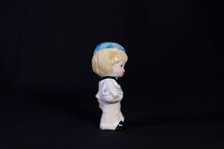 Figura niño cerámica con gorra y cestas