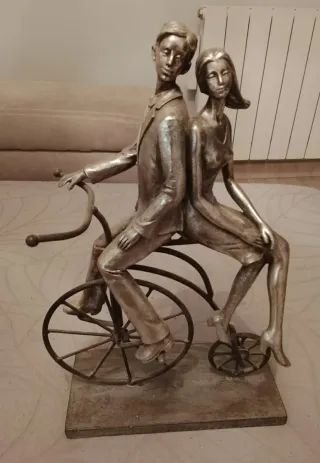 Figura pareja en bici plateada. NUEVA
