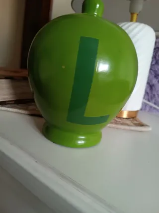 Salvadanaio verde con lettera L