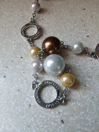 Collar de perlas y círculos plateados