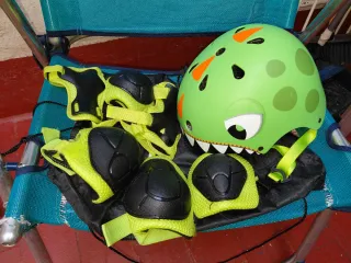 Patinete infantil verde con casco y protecciones