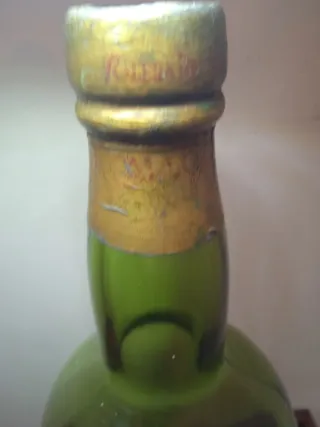 Botella de vidrio verde con detalles dorados