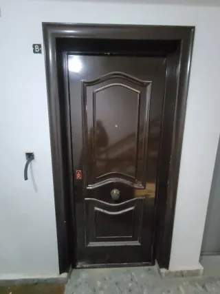 Puerta de entrada marrón por dentro blanca