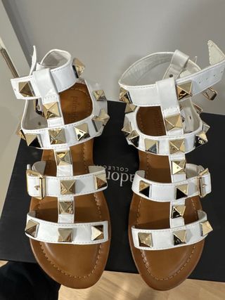 Sandalias blancas con tachuelas doradas