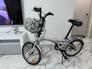 Bicicleta plegable plateada con cesta