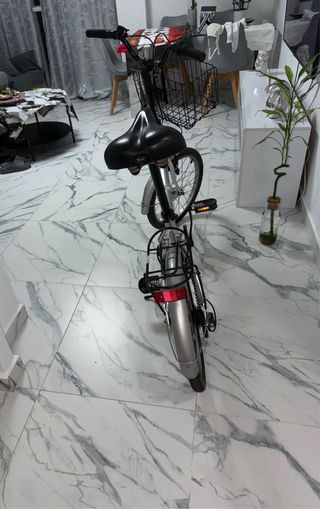 Bicicleta plegable plateada con cesta