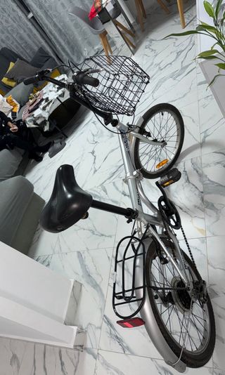 Bicicleta plegable plateada con cesta
