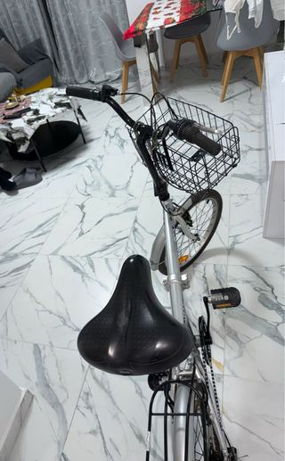 Bicicleta plegable plateada con cesta