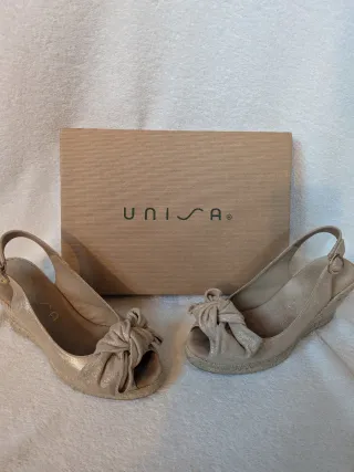 Cuñas UNISA doradas con lazo y destellos