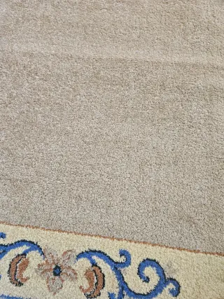 Alfombra beige con diseño floral azul