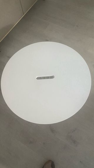 Mesa auxiliar redonda blanca.