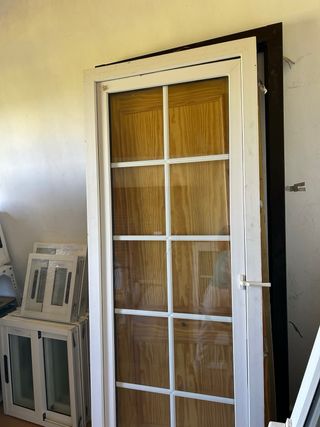 Puerta de madera con cristal y marco blanco