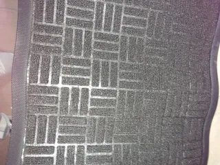 Alfombra negra de tela y plástico