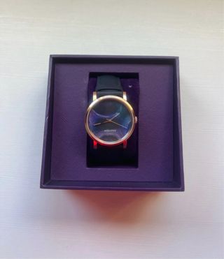 Reloj de pulsera dorado con esfera multicolor