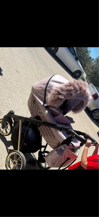 Carro de bebé rosa con capazo y detalles