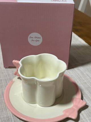 Taza de té y plato con lazo rosa