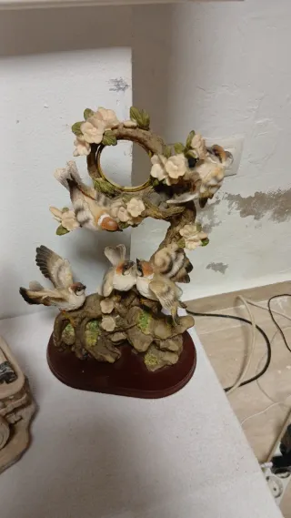 Figura de pájaros en rama con flores