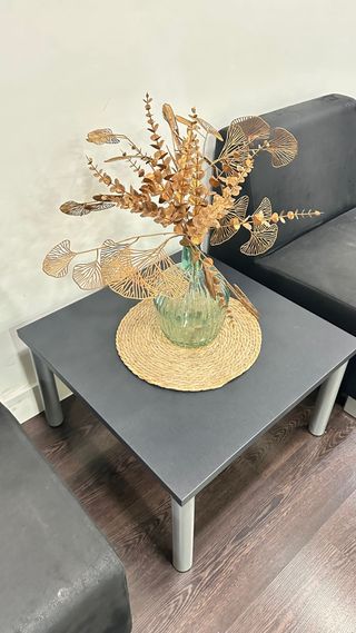 Mesa auxiliar gris con detalles dorados