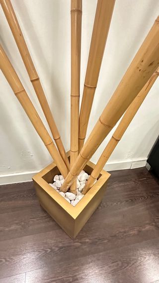 Maceta dorada con bambú y piedras