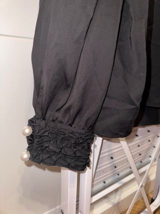 Blusa negra escote V y puños perlas