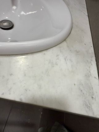 Lavabo de porcelana con encimera de mármol y grifo