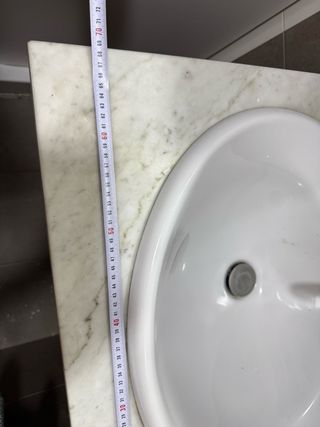 Lavabo de porcelana con encimera de mármol y grifo