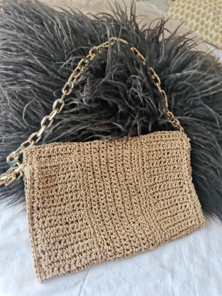 Bolso de mano tejido tipo rafia con cadena dorada