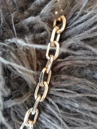 Bolso de mano tejido tipo rafia con cadena dorada