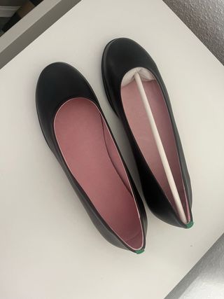 Zapatos planos negros con una raya verde