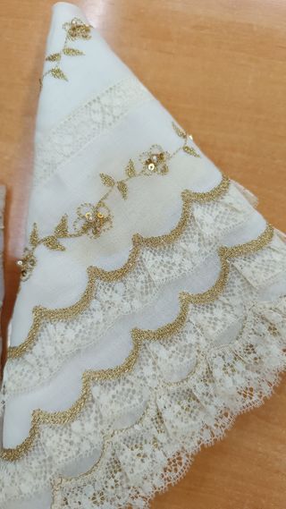 Manteleta bebé batista beige bord. oro y puntilla