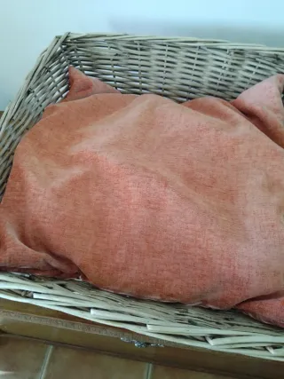 Cesto de mimbre con cojín naranja
