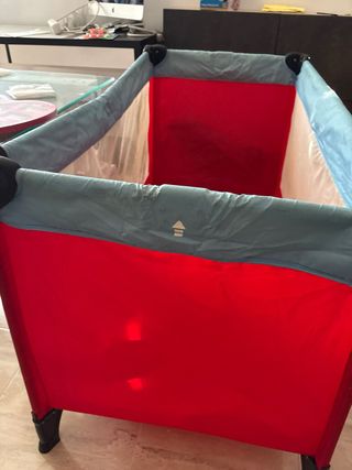 Parque cuna plegable rojo y gris.