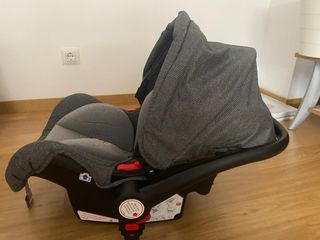 Carrito de bebé gris con funda impermeable