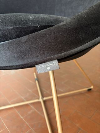 Poltroncina in velluto nero con cuscino decorativo