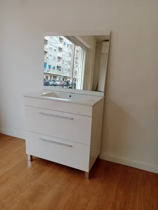 Mueble blanco con lavabo y espejo