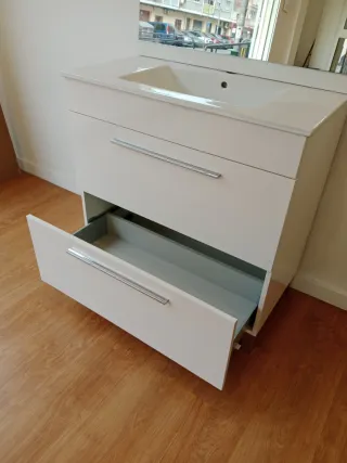 Mueble blanco con lavabo y espejo