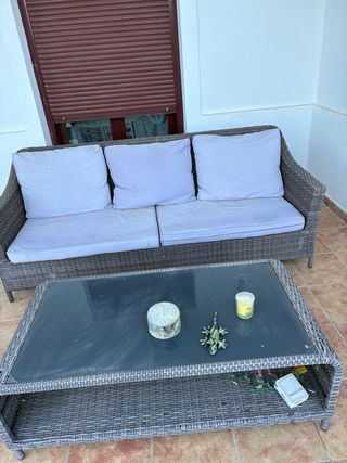 Sofá de mimbre con mesa de cristal