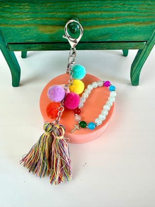 Llavero y pulsera con pompones y cruz