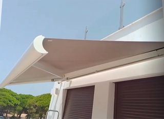 Toldo casete blanco,tela gris,  motorizado.