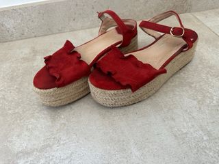 Sandalias rojas con cuña de esparto de color teja.