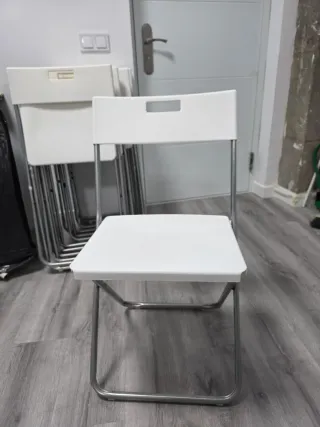 Silla plegable blanca y plateada