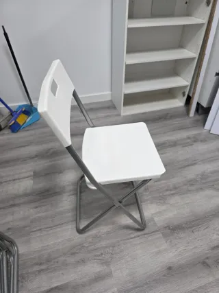 Silla plegable blanca y plateada