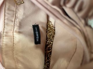 Bolso de mano rosa satinado con cadena dorada