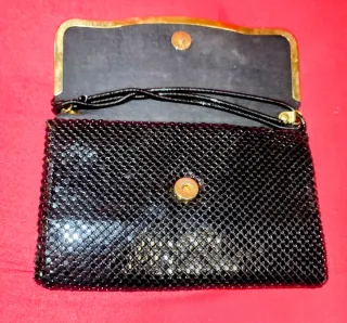 Bolso de mano negro malla metálica.