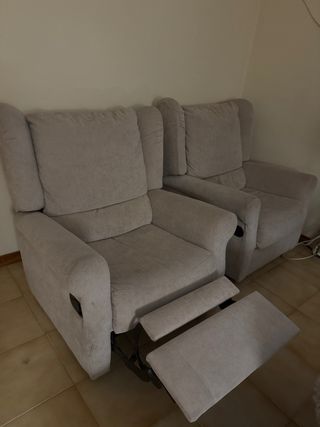 Poltrone con cuscini beige e poggiapiedi ribaltabile