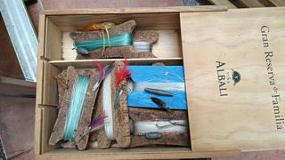 Scatola da pesca con mulinelli e esche