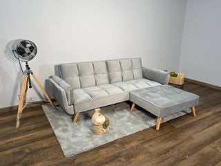 Sofá gris moderno con chaise longue a juego y puff