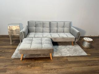 Sofá gris moderno con chaise longue a juego y puff