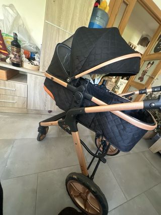 Cochecito de bebé negro y dorado